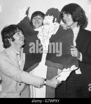 Ein lebensgroßer Karikaturschnitt von Beatle John Lennon gewinnt die liebevolle Aufmerksamkeit seiner drei Live-Begleiter (von links nach rechts) Paul McCartney, Ringo Starr und GEORGE HARRISON bei einer Presse-Cartoon-Filmvorschau von 'The Yellow Submarine' im Bowater House, Knightsbridge, London. Stockfoto