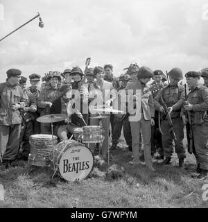 Die Beatles spielen mit einem Armeepublikum, wenn sie vor Ort für ihren neuen Film in Larkhill drehen. Von links nach rechts - Ringo Starr (am Schlagzeug), John Lennon, Paul McCartney und George Harrison. Stockfoto