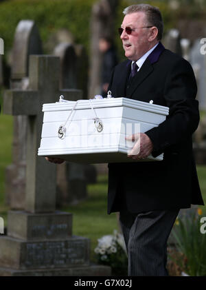 Der Sarg eines nicht identifizierten Jungen wird nach einer Trauerfeier auf dem Seafield Cemetery, Edinburgh, fast zwei Jahre nachdem er tot auf einem Pfad gefunden wurde, zu seiner Grabseite getragen. Stockfoto