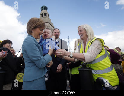 Die erste Ministerin Nicola Sturgeon hält ein Kind mit dem Parlamentskandidaten für Dundee West Chris Law während des Wahlkampfes in Dundee, Schottland. Stockfoto