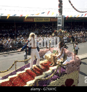 Miss Jersey Battle of the Flowers, Mary Carole Reeves, 20, wird auf ihrem Festwagen von DJ Jimmy Savile begleitet. Stockfoto