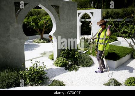 Ein Gärtner neigt zum "Beauty of Islam" Showgarten, da die Vorbereitungen vor der Eröffnung der RHS Chelsea Flower Show 2015 im Royal Hospital in Chelsea, London, fortgesetzt werden. Stockfoto