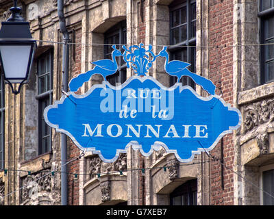 LILLE, FRANKREICH - 08. JUNI 2014: Schild über der Rue de la Monnaie, einer der ältesten Straßen der Stadt mit alten Gebäuden im Hintergrund Stockfoto