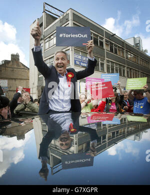 Der schottische Labour-Vorsitzende Jim Murphy ist von Labour-Anhängern und Demonstranten umgeben, während er sich auf dem Weg zur Parlamentswahl in Glasgow befindet. Stockfoto