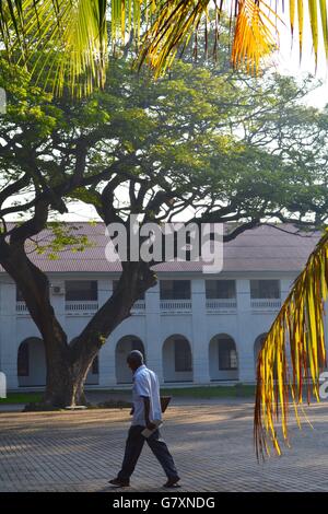 Ein Mann in den Schatten, vorbei an einem kolonialen Gebäude in Galle, Sri Lanka Stockfoto