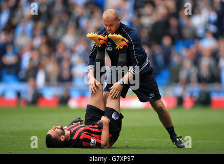 Fußball - Barclays Premier League - Manchester City / Queens Park Rangers - Etihad Stadium. Steven Caulker von Queens Park Rangers wird vom Physio behandelt Stockfoto