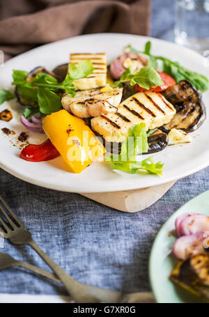 Gegrillter Halloumi mit Auberginen, Pfeffer, Knoblauch und Rucola Stockfoto