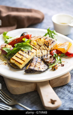 Gegrillter Halloumi mit Auberginen, Pfeffer, Knoblauch und Rucola Stockfoto