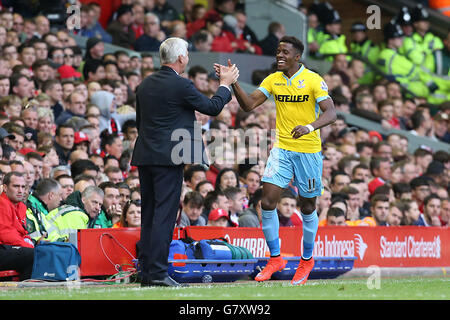 Wilfried Zaha (rechts) von Crystal Palace feiert mit Manager Alan Pardew, nachdem er beim Barclays Premier League-Spiel in Anfield, Liverpool, das zweite Tor des Spiels erzielt hatte. DRÜCKEN Sie VERBANDSFOTO. Bilddatum: Samstag, 16. Mai 2015. Siehe PA Geschichte FUSSBALL Liverpool. Bildnachweis sollte lauten: Peter Byrne/PA Wire. . . Stockfoto