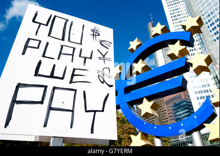 "Sie spielen, wir zahlen", Plakat der besetzen Frankfurt Bewegung neben dem Euro-Symbol vor der EZB, Europäische Zentralbank Stockfoto