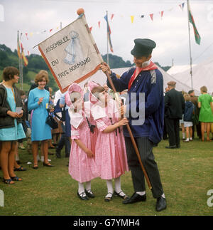 Ann, 8, und Nina Wright, 6, von Maida, London, bewundern Sie den Fahnenträger Michael Leguay von L'Assemblee du Pays Normand (Frankreich) während des Llangollen International Musical Eisteddfod. Stockfoto