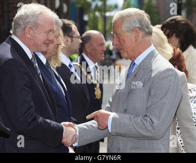 Der Prinz von Wales schüttelt vor der St. Patrick's Church in Belfast die Hände des stellvertretenden Ersten Ministers von Nordirland, Martin McGuinness (links). Stockfoto