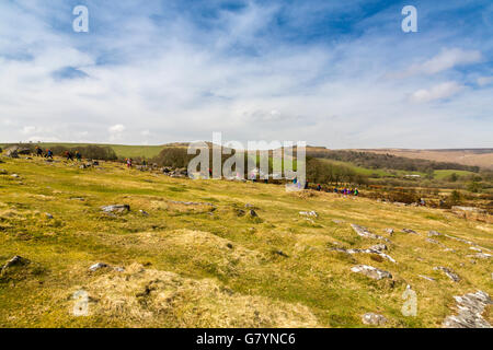 Eine Gruppe von Kindern mit Klettern hüten aufsteigend bis Hound Tor auf Dartmoor, Devon, England, UK Stockfoto