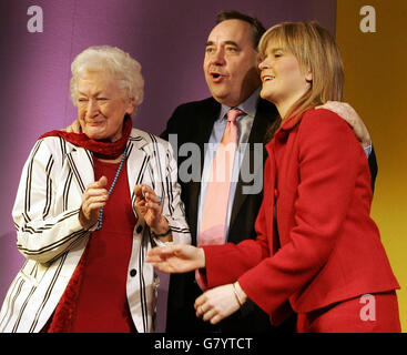 Die stellvertretende Vorsitzende der Scottish National Party, Nicola Sturgeon M.S.P.(rechts), akzeptiert die Bewillkupierungen von Parteiführer Alex Salmond M.P. und Parteipräsident Winnie Ewing (links), nachdem sie ihre Rede gehalten hat. Stockfoto