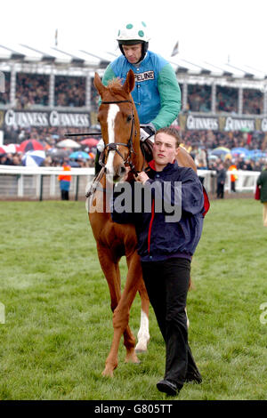 Pferderennen - Cheltenham Festival 2005 - Cheltenham Racecourse. Nun, der von Jockey Timmy Murphy gerittene Chief wird von stabilehand Cay Bonhoff für den Queen Mother Champion Steeple Chase zum Posten geführt Stockfoto