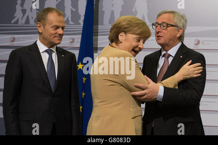 Bundeskanzlerin Angela Merkel wird auf der Bühne vom Präsidenten der Europäischen Kommission Jean Claude Juncker (rechts) begrüßt, der neben dem Präsidenten des Europäischen Rates, Donald Tusk (links), steht, während die Staats- und Regierungschefs heute auf dem Gipfel der Östlichen Partnerschaft in Riga, Lettland, zusammentreffen. Stockfoto