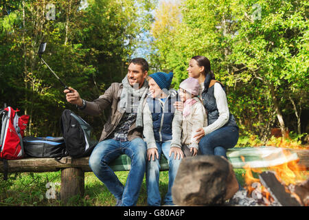 Familie mit Smartphone unter Selfie nahe am Lagerfeuer Stockfoto