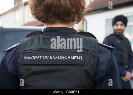 Immigration Enforcement Officers razzia ein Wohneigentum auf der Suche nach illegalen Einwanderern in Southall, West London. Stockfoto