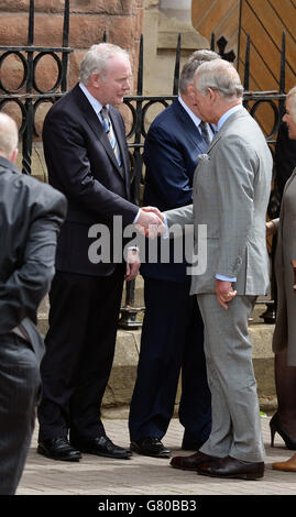 Der Prinz von Wales schüttelt sich die Hände mit dem stellvertretenden Premierminister von Nordirland, Martin McGuinness (links), als er die St. Patrick's Church in Belfast besucht. Stockfoto
