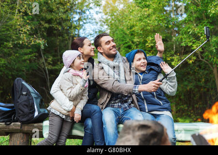Familie mit Smartphone unter Selfie nahe am Lagerfeuer Stockfoto