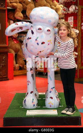 Flora Norris ist sieben Jahre alt und kommt aus Brighton mit Shaun, dem Schaf, während einer Veranstaltung von Nutricia, um im Spielzeugladen Hamleys in der Londoner Regent Street auf die medizinische Ernährung aufmerksam zu machen. Stockfoto