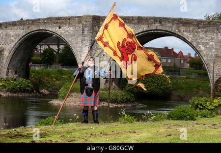 Das Mitglied der Wallace Society Eddie McNeill aus Strachur schwingt eine wehende Löwenfahne von der Stirling Bridge als Denkmal an der Stelle der "Braveheart Schlacht", wo William Wallace und Andrew de Moray Schottland zum Sieg bei der Schlacht von Stirling Bridge im Jahr 1297 führten. Stockfoto