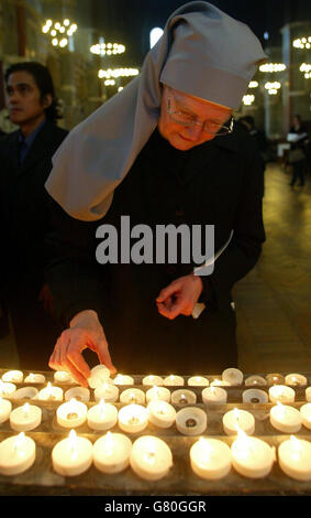 Eine Nonne zündet eine Kerze an der Westminster Cathedral an, wo eine Requiem-Messe unter der Leitung von Kardinal Cormac Murphy-O'Connor abgehalten wurde. Stockfoto