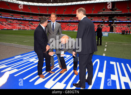 TV-Moderator Mark Clemmit (Mitte) schaut sich die zerrissene Hose von Glynn Snodin, Assistentin von Preston North End (links), genauer an, während Manager Simon Grayson (rechts) darauf schaut Stockfoto