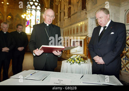 Erzbischof Sean Brady, der katholische Primas von ganz Irland (links), liest ein kurzes Gebet mit dem nordirischen Staatssekretär Paul Murphy, der ein Kondolenzbuch für Papst Johannes Paul II. Unterzeichnete Stockfoto