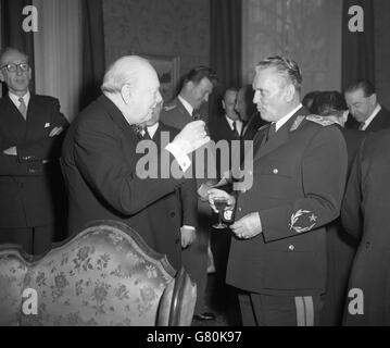 Premierminister Winston Churchill hebt sein Glas an, um bei einem Mittagessen in der jugoslawischen Botschaft in Kensington auf Marschall Josip Broz Tito, den Chef des jugoslawischen Staates, anzustoßen. Stockfoto