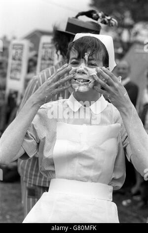 Krankenschwester Julie Sye bekommt ein Gesicht voller Pudding Pie, geworfen während der fünften jährlichen World Custard Pie Championships. Es wird in der Coxheath Fete auf dem Gelände der Coxheath Primary School in der Nähe von Maidstone, Kent, veranstaltet. Julies Team - die Lynton Lovelies - wurde Dritter und die World Custard Pie Trophy wurde von den Verteidigern, den Coxheath Birds, behalten. Stockfoto