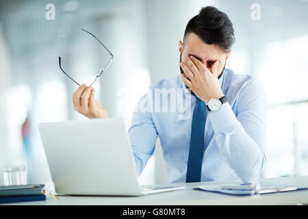 Müde von der Arbeit mit laptop Stockfoto