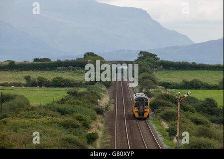 Ein Klasse 158 DMU Heads in Anglesey gebunden für Holyhead. Die Berge von Snowdonia sind im Hintergrund sichtbar. Stockfoto