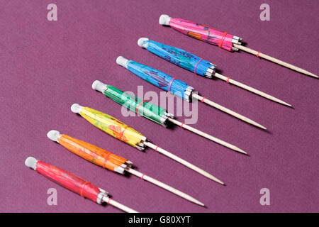 Verschiedenen cocktail Umbrelas auf weißen und violetten Hintergrund farbig Stockfoto