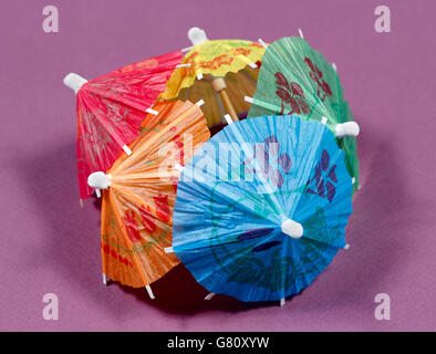 Verschiedenen cocktail Umbrelas auf weißen und violetten Hintergrund farbig Stockfoto