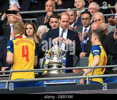 Präsident des Football Association, der Duke of Cambridge, bevor er den FA Cup an Arsenals per Mertesacker (links) und Arsenals Laurent Koscielny (rechts) übergab Stockfoto