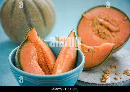 Orange Melonenscheiben in Schüssel auf Holzbrett Stockfoto