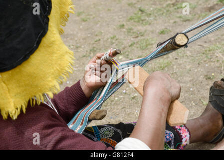 Peruanische Frau in traditioneller Kleidung Tuch das Weben auf einem Webstuhl in den Anden, Peru Stockfoto