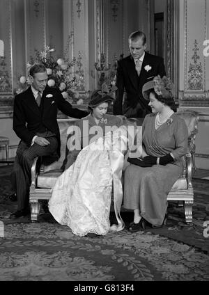 König George VI, links, der Herzog von Edinburgh, zurück, und Königin Elizabeth, rechts sehen auf als Prinzessin Elizabeth, Mitte, hält Prinz Charles nach seiner Taufe. Stockfoto