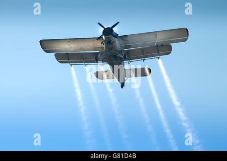 Altes Flugzeug am blauen Himmel, weiße Linien Stockfoto