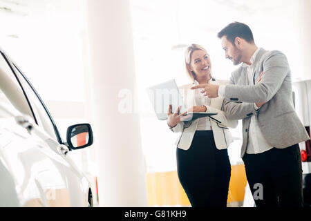 Kunde im Autohaus ein Auto suchen und Anpassen von Fahrzeug Stockfoto