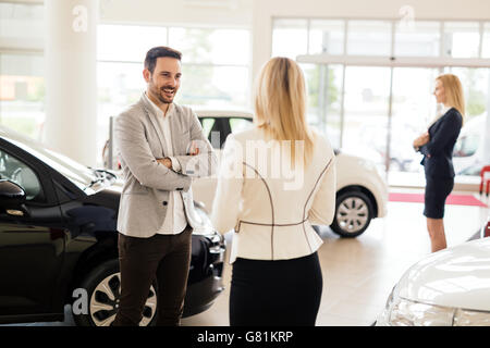 Kunde im Autohaus ein Auto suchen und Anpassen von Fahrzeug Stockfoto