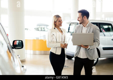 Kunde im Autohaus ein Auto suchen und Anpassen von Fahrzeug Stockfoto