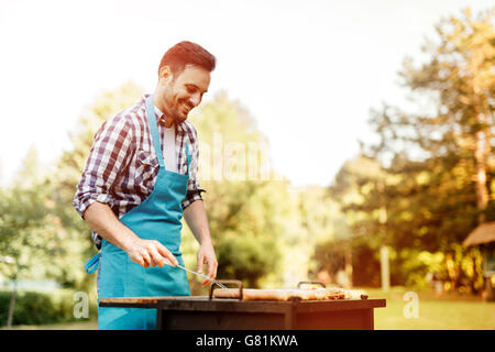 Hübscher Mann bereitet Grill im freien Stockfoto