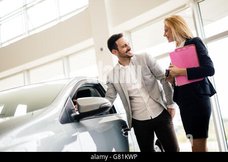 Kunde im Autohaus ein Auto suchen und Anpassen von Fahrzeug Stockfoto