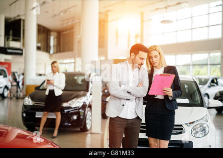 Kunde im Autohaus ein Auto suchen und Anpassen von Fahrzeug Stockfoto