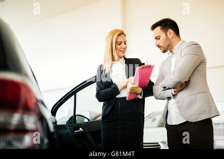 Kunde im Autohaus ein Auto suchen und Anpassen von Fahrzeug Stockfoto