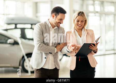 Kunde im Autohaus ein Auto suchen und Anpassen von Fahrzeug Stockfoto