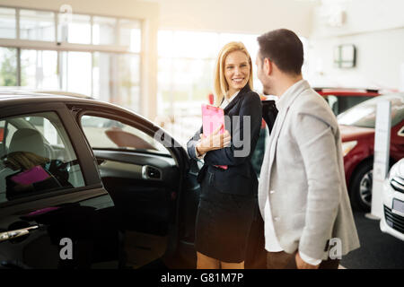 Kunde im Autohaus ein Auto suchen und Anpassen von Fahrzeug Stockfoto