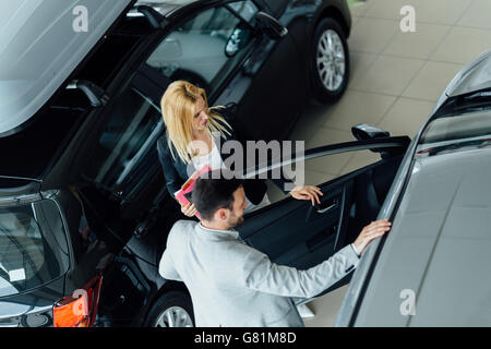 Kunde im Autohaus ein Auto suchen und Anpassen von Fahrzeug Stockfoto